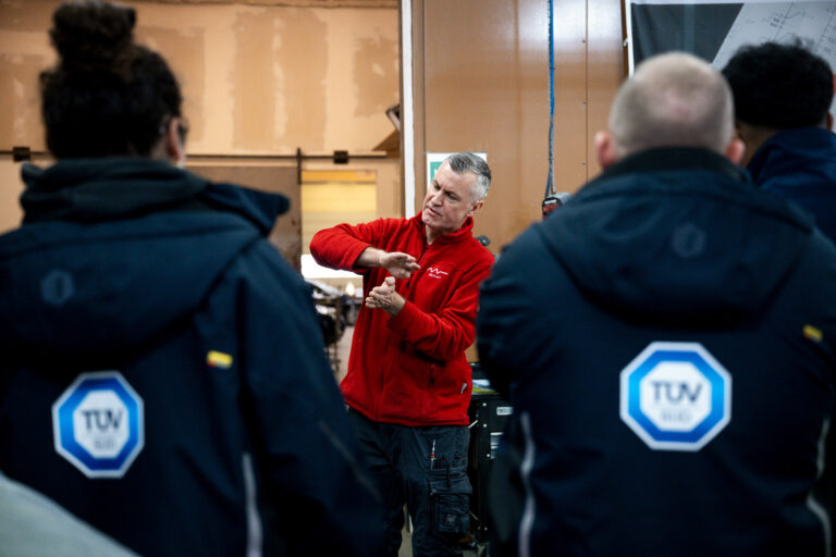 Experte erklärt Teilnehmern bei einem Smart Repair Kurs für TÜV Süd etwas.